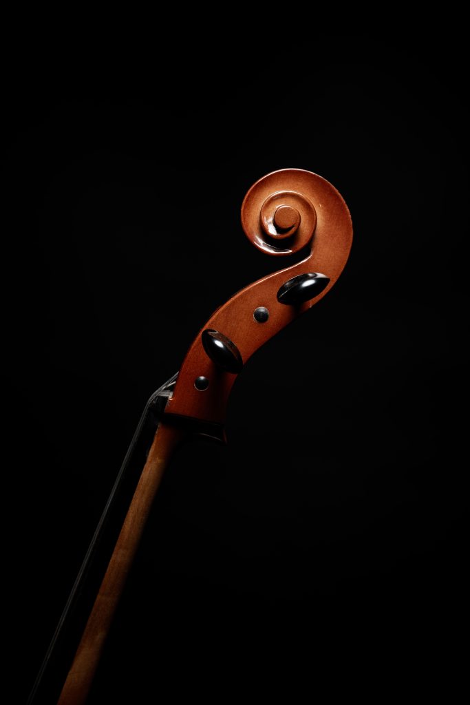 Close-up of a violin scroll with a dark and elegant atmosphere, perfect for music-related concepts.